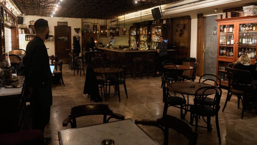 Varias personas pasan el tiempo en un bar casi vacío en la calle Hamra de Beirut, Líbano.