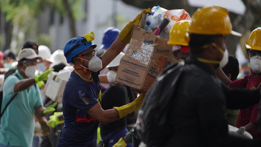 Los rescatistas distribuyen paquetes de alimentos a los equipos de rescate y voluntarios que buscan entre los escombros cuatro días después del terremoto.
