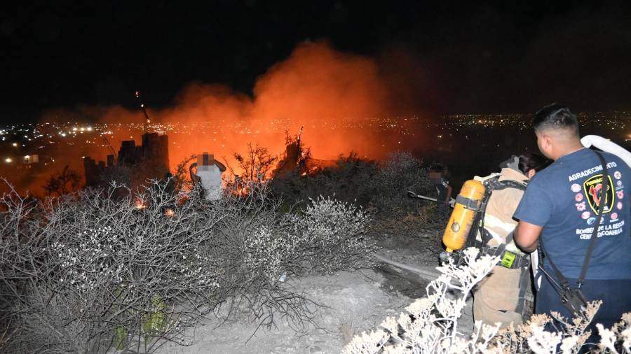 Elementos del Cuerpo de Bomberos inspeccionan los restos de la vivienda consumida por el incendio en la colonia Veteranos de la Revolución.