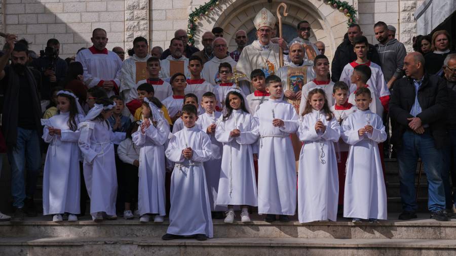 El cardenal Pierbattista Pizzaballa, patriarca latino de Jerusalén, con parroquianos palestinos tras dirigir una misa antes de las celebraciones navideñas en la iglesia católica de la Sagrada Familia en Ciudad de Gaza.