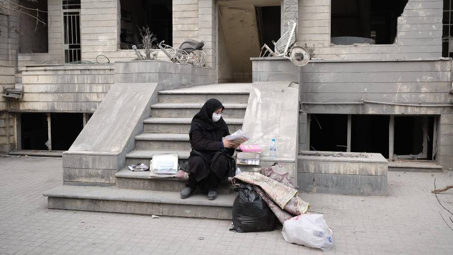 GRAF9203. TEHERÁN (IRÁN), 12/03/2026.- Una vecina revisa documentos frente a su casa del barrio de Resalat que sufrió un ataque de Estados Unidos e Israel el lunes. Ya había oscurecido y Marzieh se encontraba en pijama viendo la televisión cuando su casa comenzó a temblar y su vida, de repente, se convirtió en una película de terror: su barrio había sido alcanzado por tres misiles. EFE/Jaime León