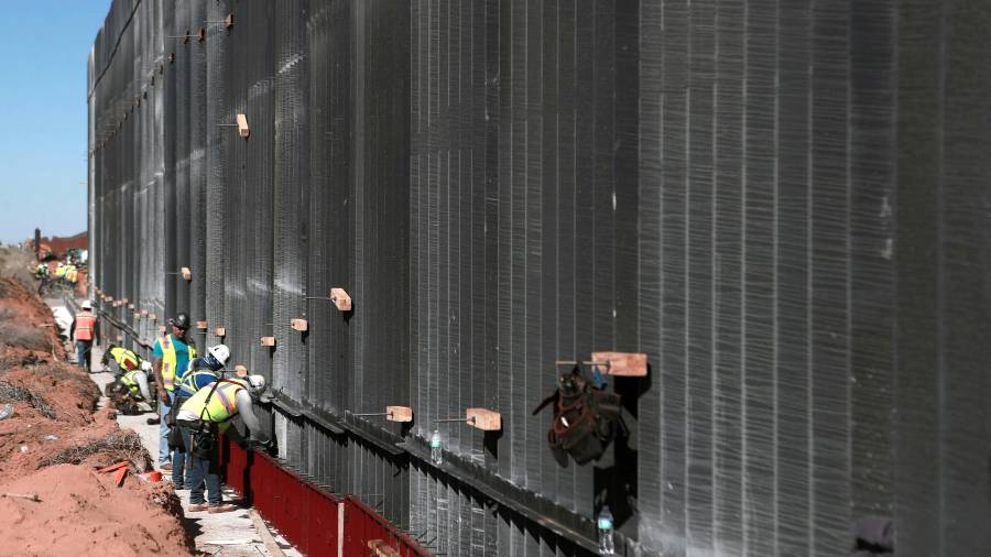 Obreros estadounidenses construyen un muro fronterizo, entre El Paso en Texas y Ciudad Juárez, Chihuahua México.