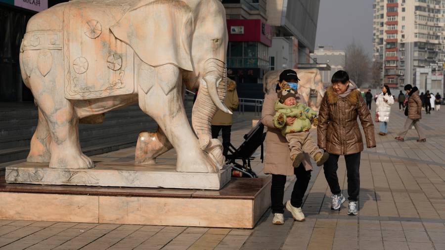 Una mujer carga a un niño en Beijing, China, el 15 de enero de 2026.