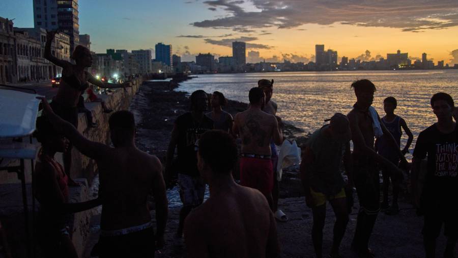 La gente observa la puesta de sol desde el Malecón durante un apagón en La Habana, el lunes 16 de marzo de 2026.