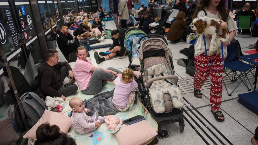 Varias personas se refugian en una estación subterránea del metro mientras las sirenas advierten de ataques aéreos inminentes lanzados por Irán, en Ramat Gan, Israel.
