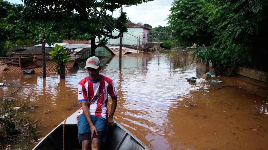 Javier Barreto navega en una embarcación por una calle inundada por el río Paraná, tras las fuertes lluvias que provocaron su desbordamiento en Ciudad del Este, Paraguay, el viernes 16 de octubre de 2026.