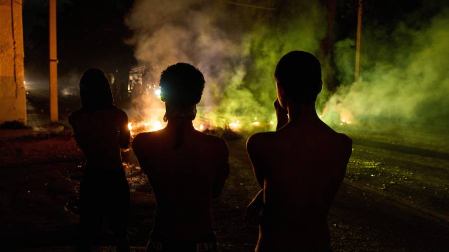 Varias personas observan una barricada levantada por residentes que protestan contra los prolongados cortes de electricidad en La Habana, Cuba, informó la agencia AP en campo.