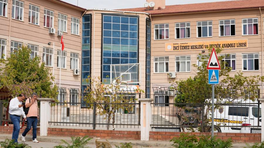 Gente camina junto a una escuela secundaria y profesional en el distrito Turgutlu en la provincia de Manisa, en el oeste de Turquía, después de que un tirador abriera fuego cerca de la escuela.