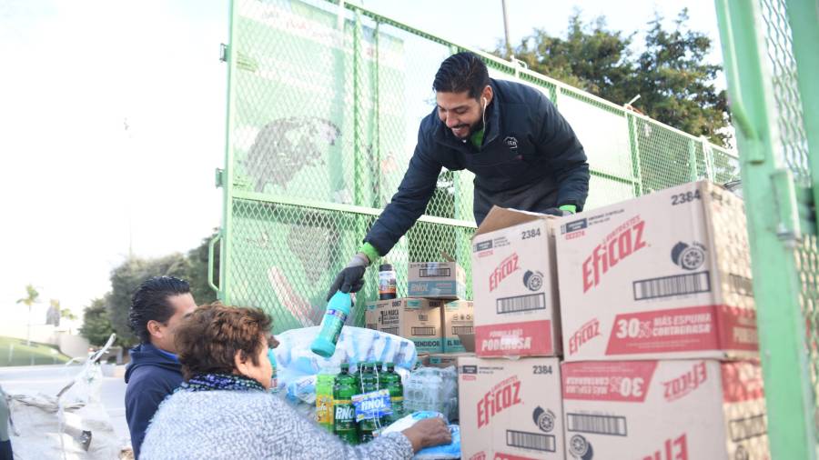 Personal descarga insumos que se entregan a cambio de materiales reciclables durante las jornadas del programa.