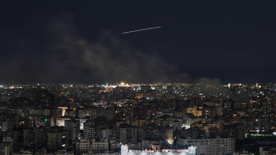 Un avión de Middle East Airlines vuela mientras se eleva humo tras los ataques aéreos israelíes en Dahiyeh, un suburbio al sur de Beirut, Líbano.