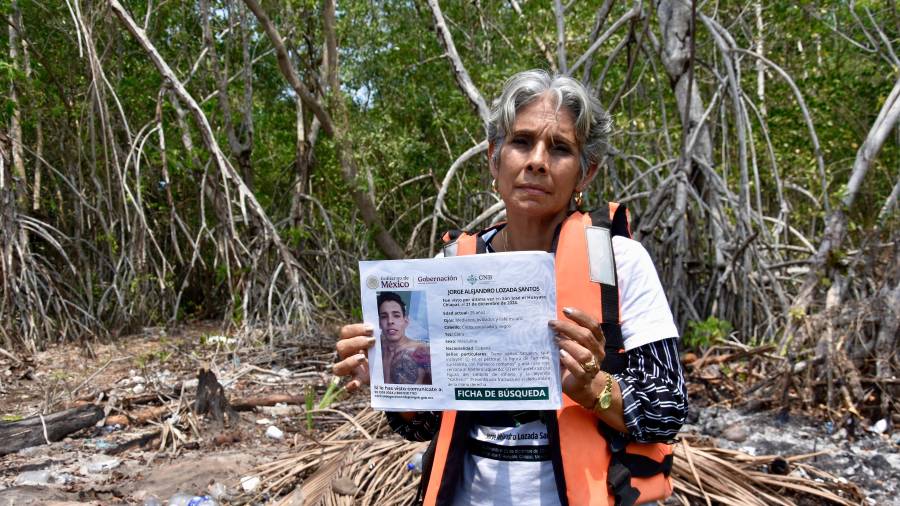 La cubana Alicia Santos Torres muestra un cartel de su hijo desaparecido, Jorge Alejandro Lozada, en San José Hueyate, Chiapas, durante una búsqueda de migrantes que desaparecieron a finales de 2024.