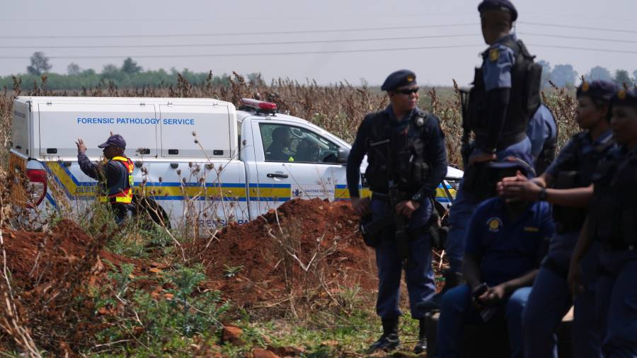 Investigadores forenses trabajan en el lugar donde se encontró el cuerpo de una mujer a las afueras de Johannesburgo, Sudáfric.