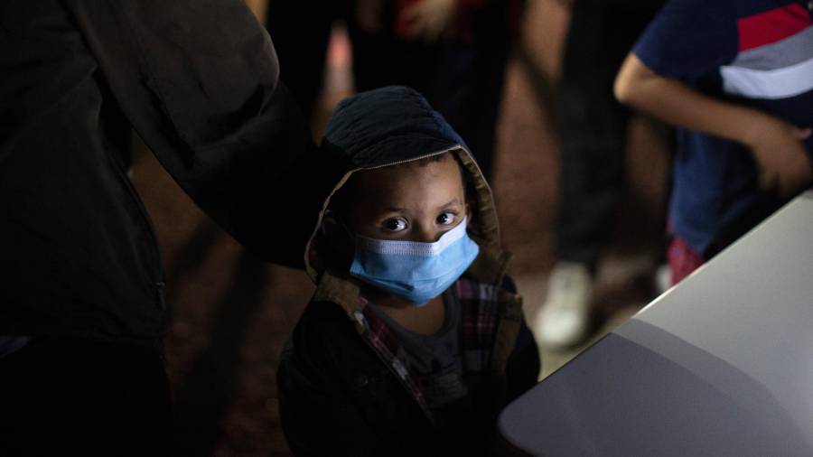 Un menor no acompañado levanta la vista mientras espera responder a las preguntas de un agente de la Patrulla Fronteriza en un centro de recepción, el 24 de marzo de 2021, en Roma, Texas.
