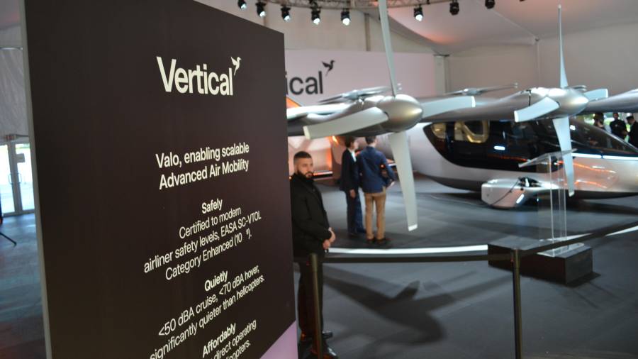 Unas personas observan a un taxi volador eléctrico de la compañía Vertical Aerospace expuesto en Miami Beach, Florida.