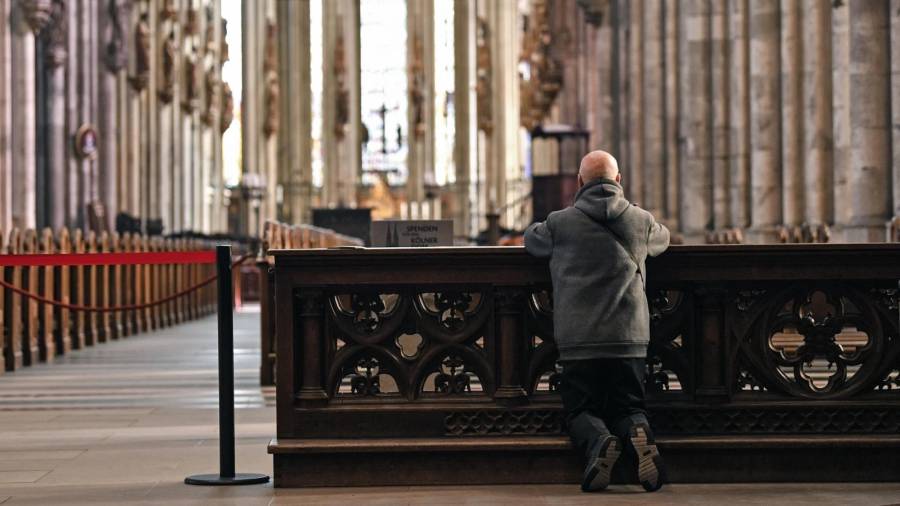 Una persona reza en la Catedral de Colonia, Alemania.
