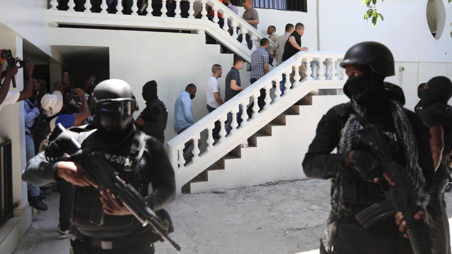 Colombianos y haitianos implicados en el asesinato en 2021 del presidente haitiano Jovenel Moisés son escoltados esposados a su audiencia judicial en Puerto Príncipe, Haití, el 26 de mayo de 2025.