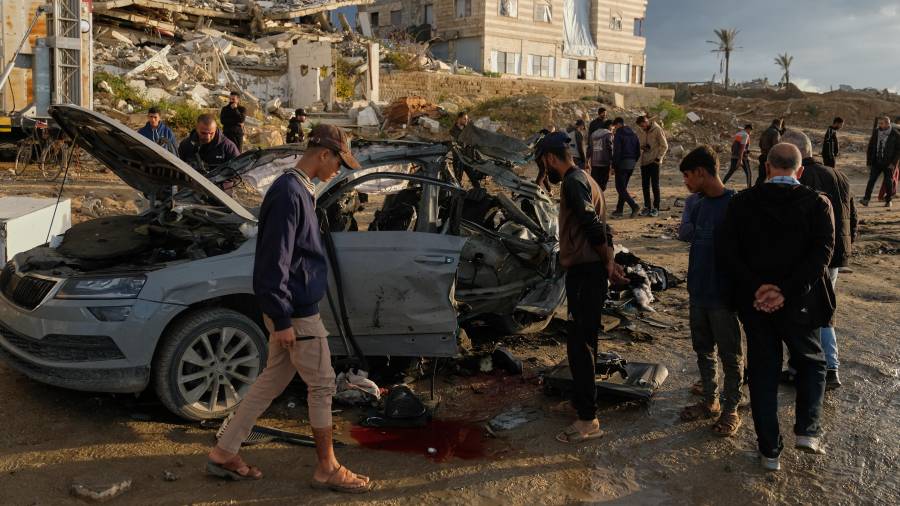 Varios palestinos observan un auto destruido tras un ataque israelí en la Ciudad de Gaza; en esta agresión se reportó la muerte del número 2 de Hamás.