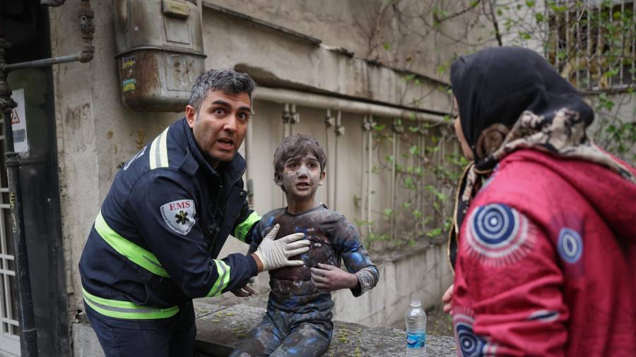 Un paramédico asiste a un niño herido en un ataque aéreo que impactó un edificio residencial, en el marco de la campaña militar estadounidense-israelí en Teherán, Irán, el sábado 28 de marzo de 2026.