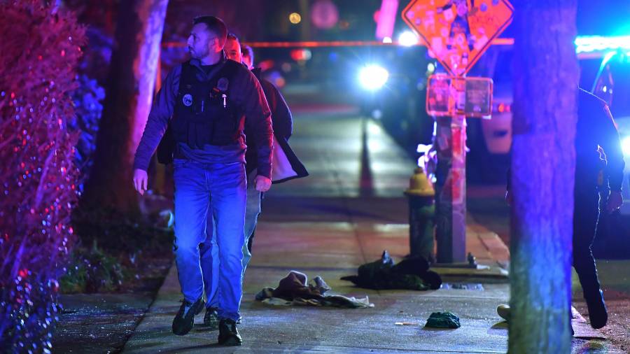 Un policía pasa entre prendas de ropa en una acera cerca de la entrada de la Universidad de Brown, durante la investigación del tiroteo.