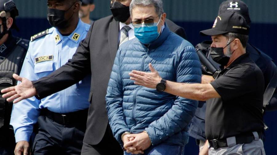 El momento en que el expresidente hondureño Juan Orlando Hernándezfue trasladado a una aeronave para ser extraditado a Estados Unidos, en una base de la Fuerza Aérea en Tegucigalpa, Honduras, el 21 de abril de 2022. FOTO: AP / ELMER MARTÍNEZ