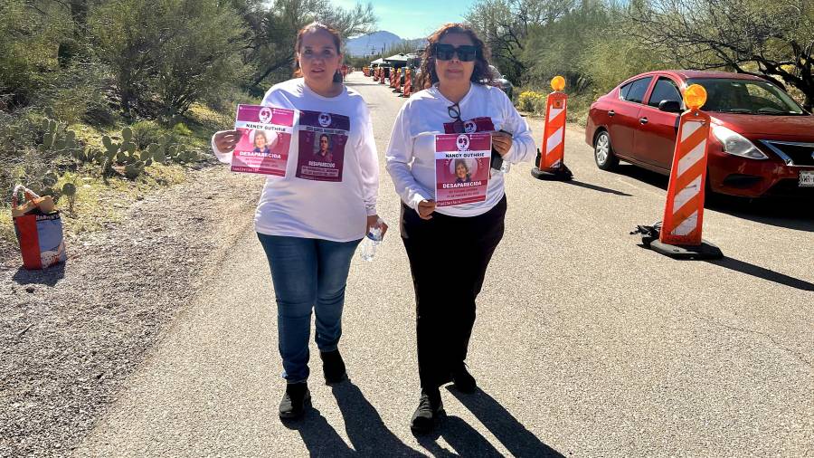 Integrantes del grupo Madres Buscadoras de Sonora, Patricia Ramírez (i) y Guadalupe Tello, sostienen carteles con la imagen de Nancy Guthrie, de 84 años, en Tucson.
