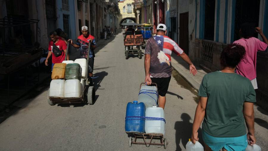 Varias personas transportan agua durante un apagón en La Habana, Cuba, el lunes 3 de agosto de 2026.