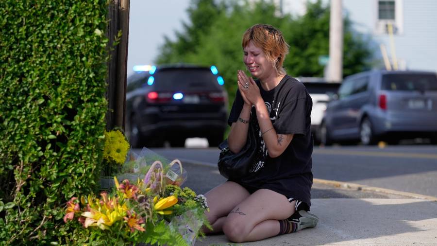 Una mujer ora tras deja flores cerca del sitio donde un hombre fue abatido a tiros por agentes del Servicio de Inmigración y Control de Aduanas de Estados Unidos (ICE, por sus siglas en inglés) en Biddeford, Maine.