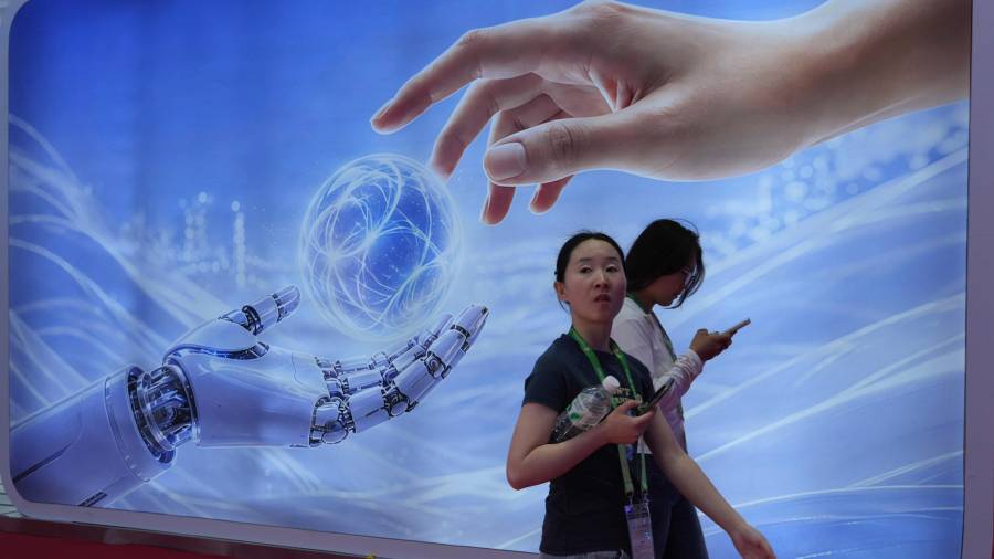 Visitantes caminan junto a un cartel con una mano humana y una robótica en la Expo Internacional China de Cadena de Suministro en Beijing, el lunes 22 de junio de 2026.