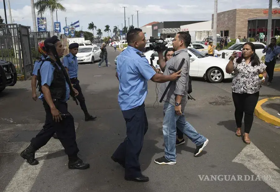 $!Un agente de la Policía Nacional obstruye el paso a un camarógrafo en una protesta en Managua para exigir la liberación de presos políticos.