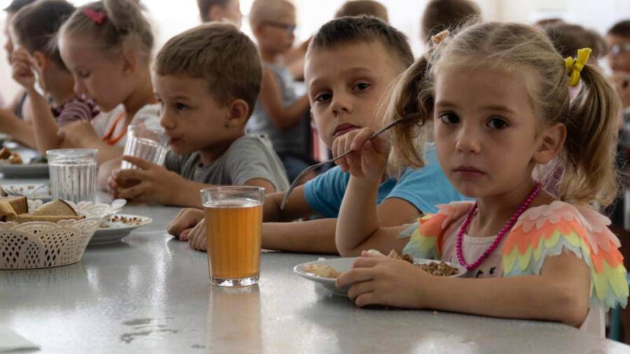 Niños de un orfanato de la región de Donetsk comen en un campamento en Zolotaya Kosa, un asentamiento a orillas del mar de Azov, en la región de Rostov (suroeste de Rusia), el 8 de julio de 2022.