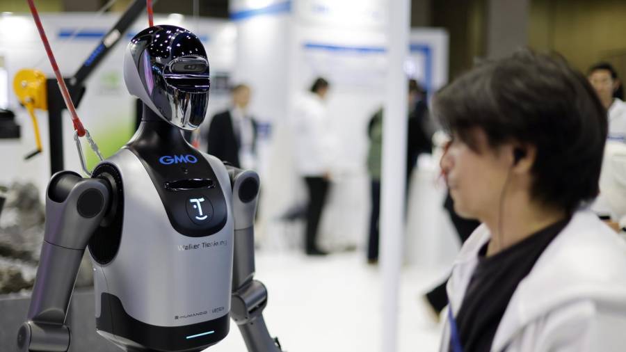 Un miembro del personal se encuentra junto al robot “Walker E” en el stand de GMO AI and Robotics Corporation durante la Exposición Internacional de Robots 2025 (iREX2025) en Tokio, Japón.