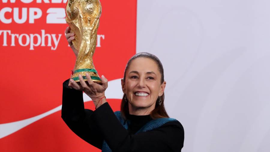 La presidenta de México, Claudia Sheinbaum, sostiene el trofeo de la Copa Mundial de Fútbol en el Palacio Nacional de la Ciudad de México.