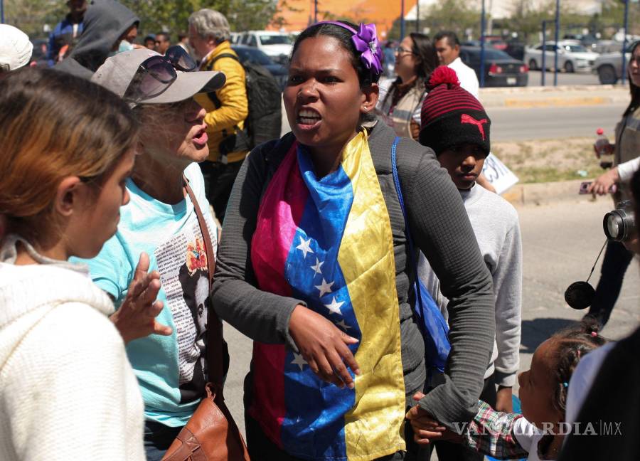 $!Mujer migrante venezolana, con una bandera de su país alrededor de su cuello, dijo que eran “unos desgraciados...y son unos inhumanos”.