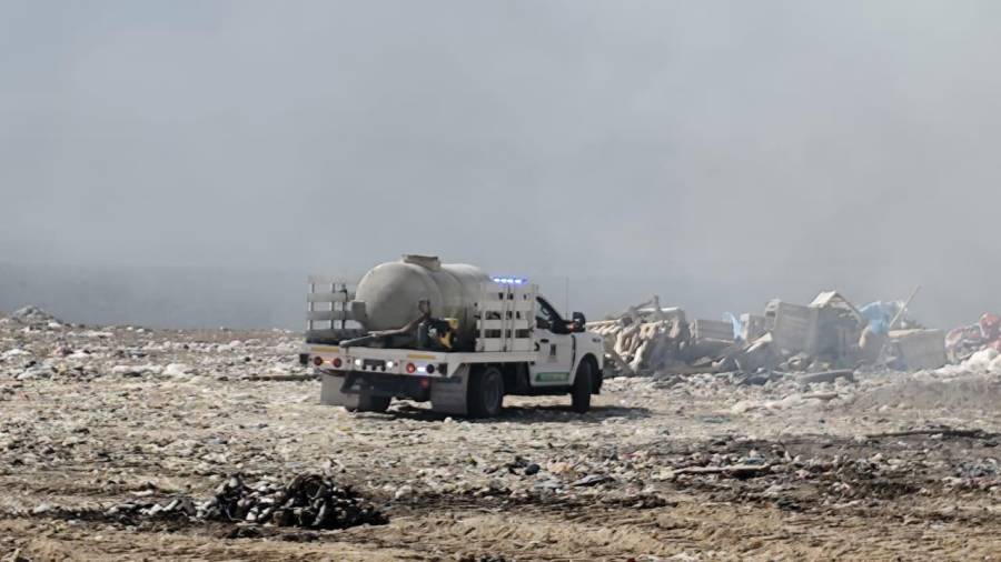 Los equipos trabajan en conjunto para controlar el fuego en un relleno sanitario.