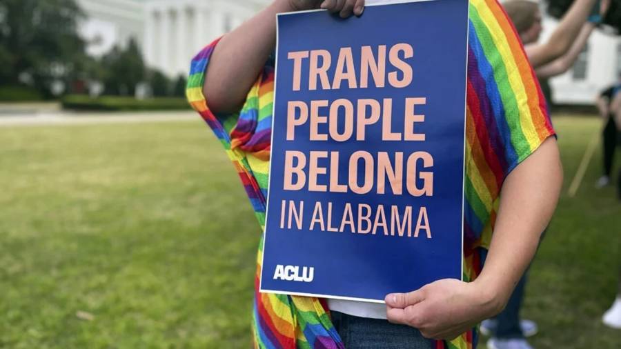 Una persona sostiene un cartel que dice “Las personas trans pertenecen a Alabama” en una protesta frente al Capitolio estatal de Alabama en Montgomery.