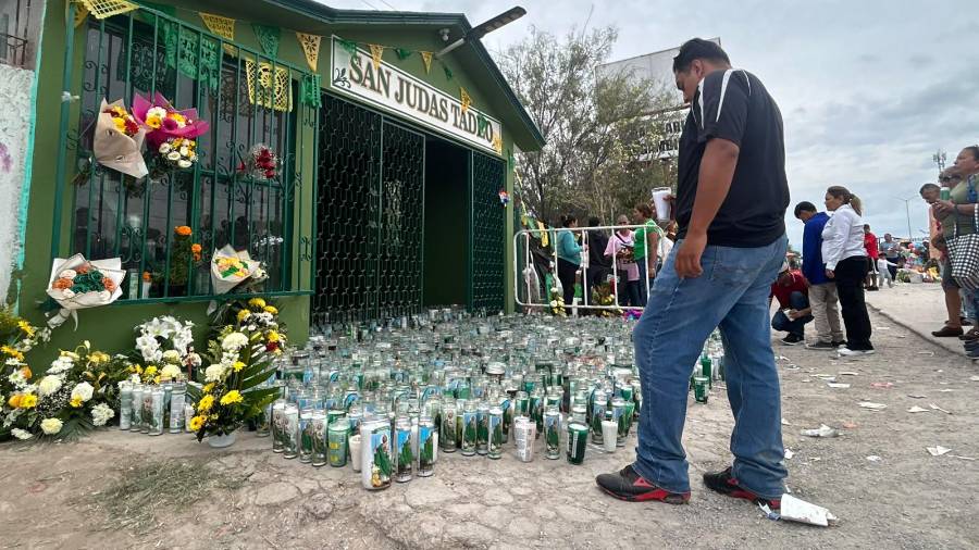 Un devoto observa las veladoras colocadas a la entrada del templo durante la jornada de celebración.