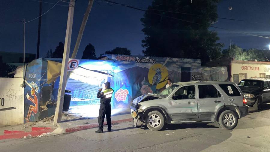El impacto derribó un poste de concreto y causó daños en la fachada del establecimiento.