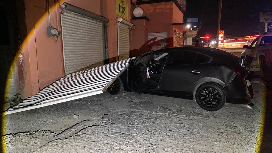 El fuerte impacto provocó que uno de los vehículos Mazda fuera proyectado contra el portón de un negocio, el cual quedó completamente derribado tras el accidente registrado durante la madrugada.