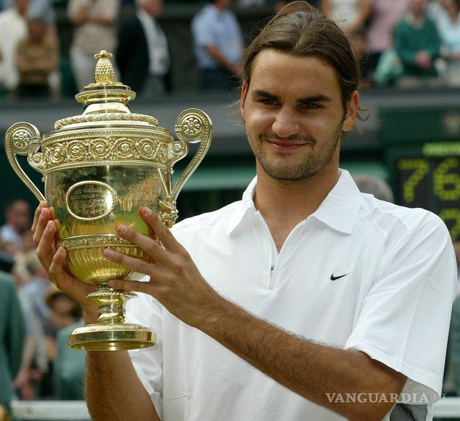 $!Roger Federer sostiene el trofeo tras de ganar la final contra Mark Philippoussis en Wimbledon, el domingo 06 de julio de 2003.