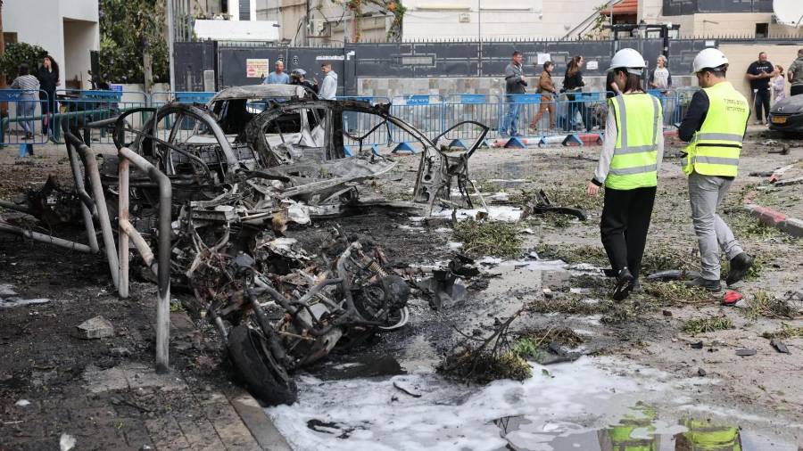Personal de emergencia israelí inspecciona coches calcinados tras el impacto de fragmentos de un misil balístico iraní interceptado en Tel Aviv.