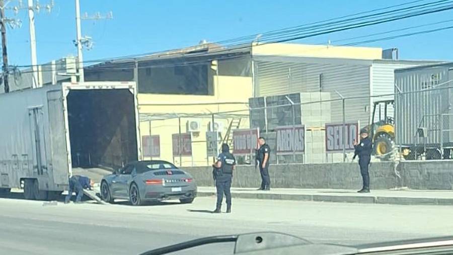 Elementos de seguridad municipal y estatal resguardaron la descarga de dos vehículos Porsche transportados en un tráiler sobre la carretera 57, a la altura de la colonia San Joaquín.