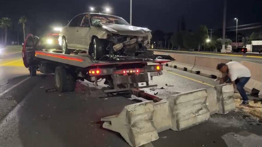 El Chevrolet Malibu fue remolcado luego de que terminó volcado sobre su costado derecho tras impactarse contra el muro de contención.