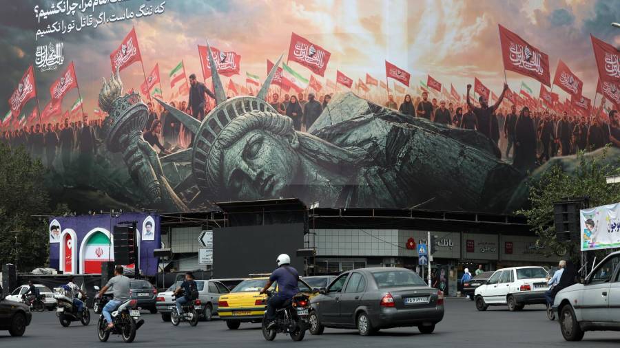 Unos iraníes pasan junto a una valla publicitaria antiestadounidense en Teherán, Irán el 9 de septiembre de 2026.