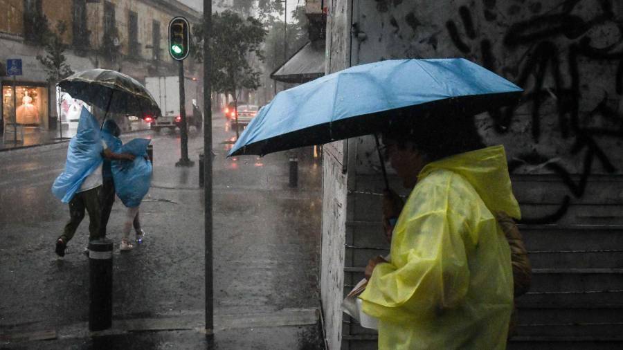 CIUDAD DE MÉXICO, 12MAYO2026.- Capitalinos se protegen de las altas lluvias registradas está tarde en la capital. FOTO: MARIO JASSO/CUARTOSCURO.COM