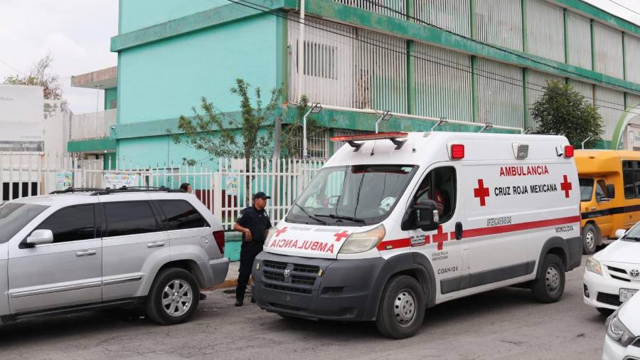 Una ambulancia de la Cruz Roja permanece en el exterior de la primaria Francisco I. Madero, en la colonia El Pueblo, tras la movilización por el accidente de un alumno.