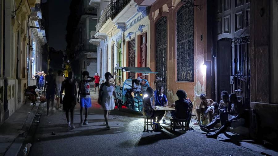 Personas alumbran con lámparas una calle durante un apagón en La Habana. Un promedio de dos o tres horas de electricidad tendrán los 9.4 millones de cubanos este jueves.