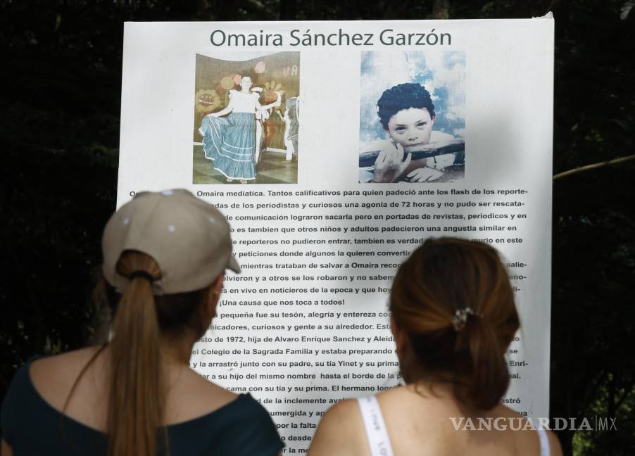 $!Fotografía del 5 de noviembre de 2025 que muestra a dos personas leyendo un cartel en un altar en honor a Omayra, en Armero, Colombia.