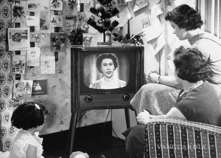 $!Una familia de Londres mira a la reina Isabel II en una pantalla de televisión durante el primer discurso de Navidad de la reina el 26 de diciembre de 1957. AP