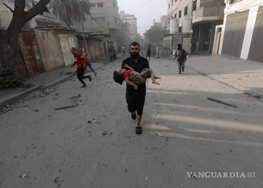 $!Un palestino carga a una niña herida tras los ataques aéreos israelíes en el norte de Gaza.