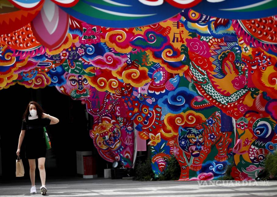 $!Una mujer con mascarilla camina junto a las decoraciones en un centro comercial en Bangkok, Tailandia. EFE/EPA/Rungroj Yongrit